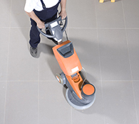 Janitor high speed polishes a commercial floor 